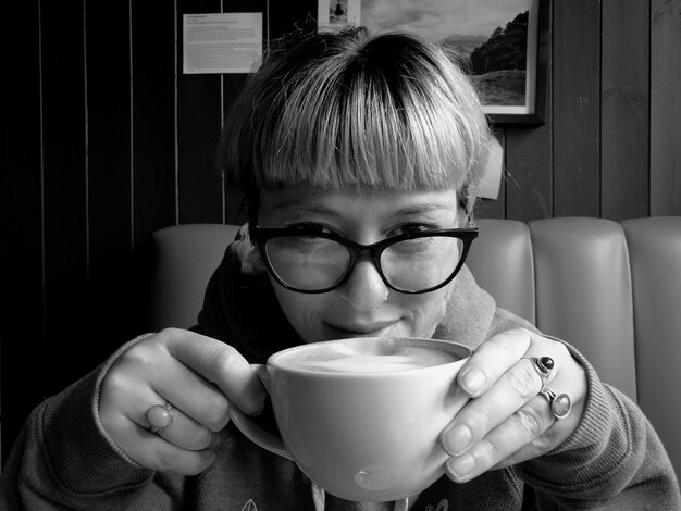 Foto ritratto ravvicinato di una donna che beve caffè seduta sul divano