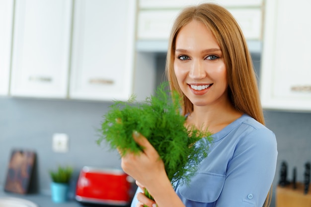 Close up portrait of a woman holding fresh greens