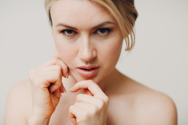 close-up portrait of woman holding hands over white background