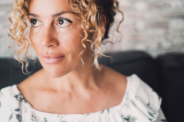 Close up portrait of woman looking on her side with independent expression on face Mindful female people big eyes Blepharoplasty and filler lips hyaluronic acid beauty health Beautiful lady indoor