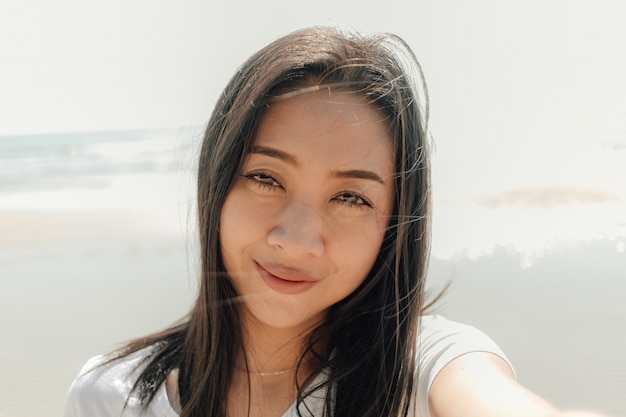 Close up portrait of woman outdoor on the sunny beach in summer.