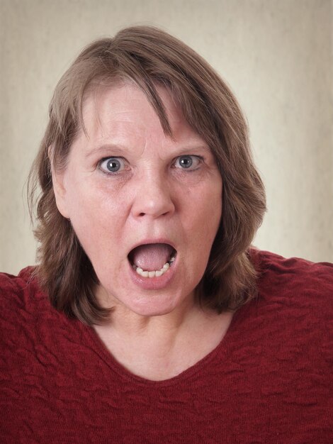 Photo close-up portrait of woman shouting against wall