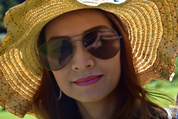 Close-up portrait of woman wearing sunglasses and hat