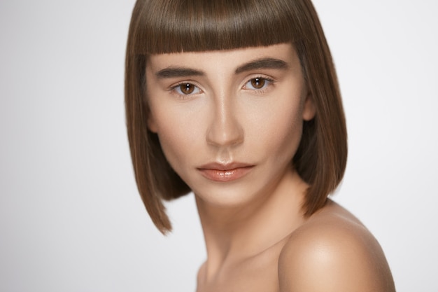 Close-up portrait of woman with bangs, beautiful model with fresh daily make-up and straight hairstyle