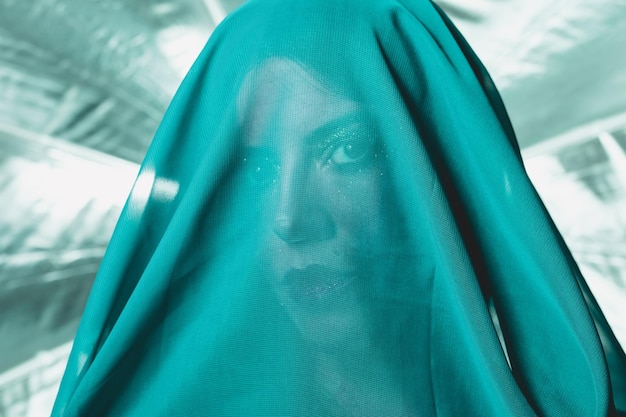 Photo close-up portrait of woman with face covered by fabric