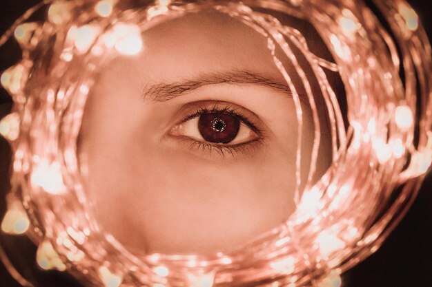 Photo close-up portrait of woman with illuminated string lights