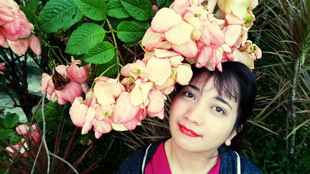 Close-up portrait of woman with pink flowers