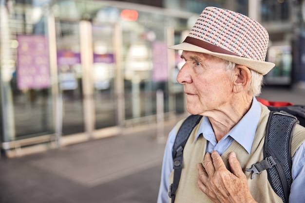 Close up portrait of a worried man with his hand on his chest staring into the distance