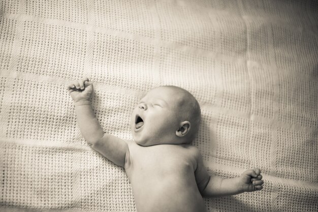 閉じる。あくびをする新生児の肖像画。レトロなスタイルの写真