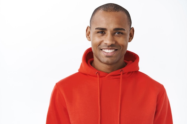 Close-up portrait of young african-american adult man in red hoodie, smiling happy