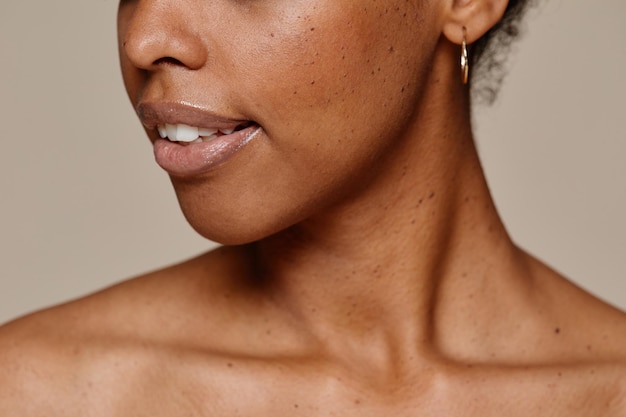 Close up portrait of young AfricanAmerican woman demonstrating beautiful natural skin and white teeth smile copy space