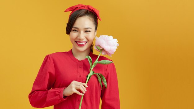 Close up portrait of young beautiful asian woman holding pink peony flower