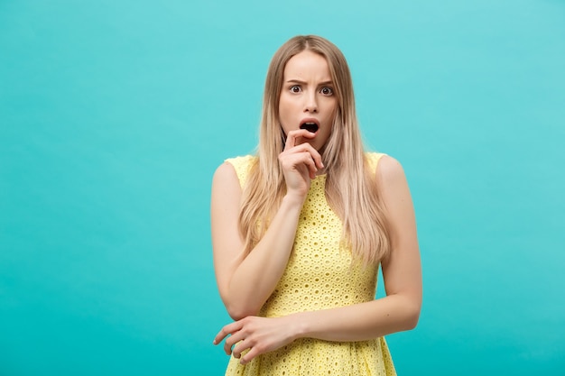 Close up Portrait young beautiful attractive girl shocking with something. Blue Pastel Background. Copy space.