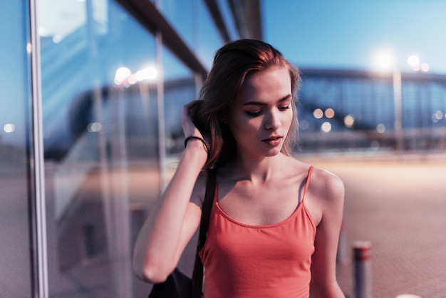 Close up portrait of young beautiful girl walking at the evening time near the buildings