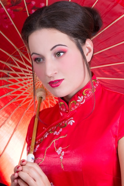 Photo close up portrait of young beautiful woman in red japanese dress with umbrella