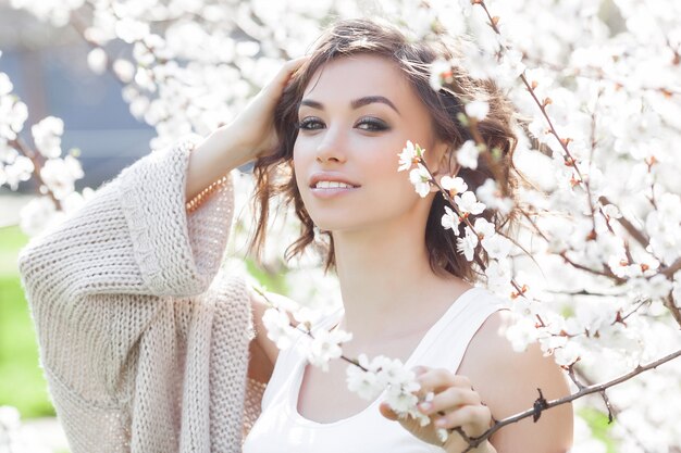 Foto chiuda sul ritratto di giovane bella donna sulla molla. ragazza attraente con i fiori. trucco primavera.