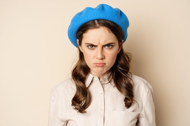 Close up portrait of young beautiful woman sulking looking angry and disappointed grimacing displeas...