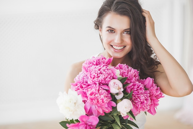 Close up portrait of young beautiful woman with flowers indoors