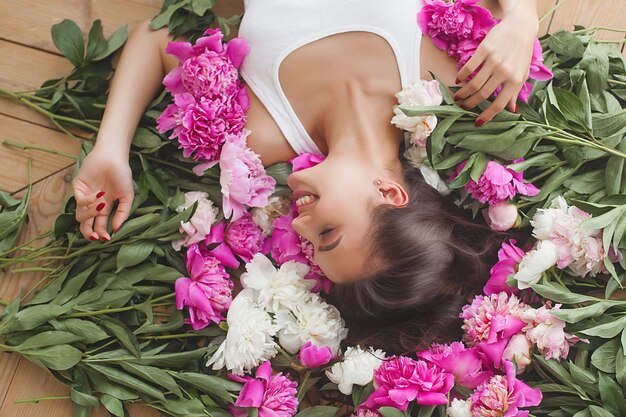 屋内の花を持つ若い美しい女性の肖像画をクローズアップ