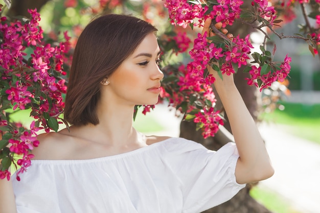 完璧な滑らかな肌を持つ若い美しい女性の肖像画を閉じます。花の魅力的な女性。美しい女性の顔の肖像画。