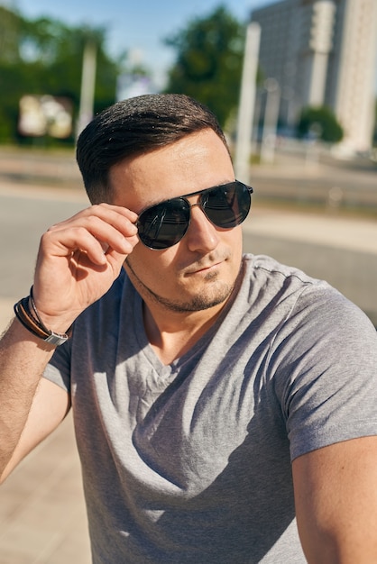 Close-up portrait of a young caucasian man with a beard. The guy looks over the glasses