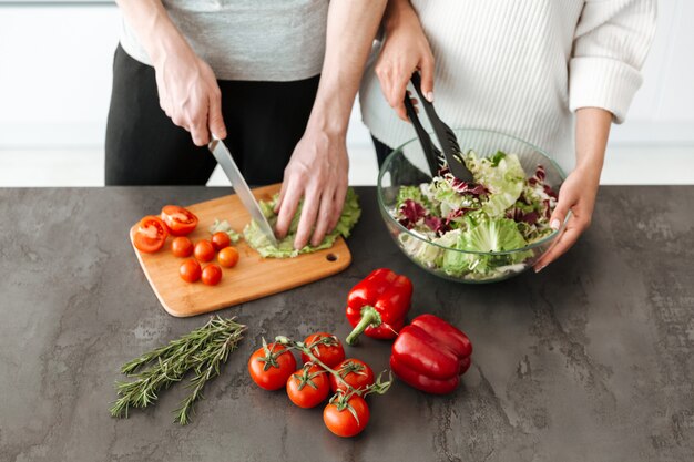 Close up portrait of a young couple cooking salad