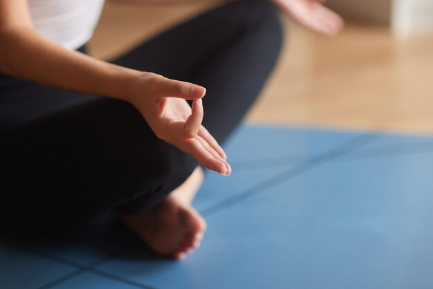 Close up portrait of young healthy woman sitting in lotus\
position and meditating half lotus pose wi