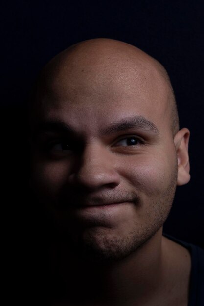 Close-up portrait of young man against black background