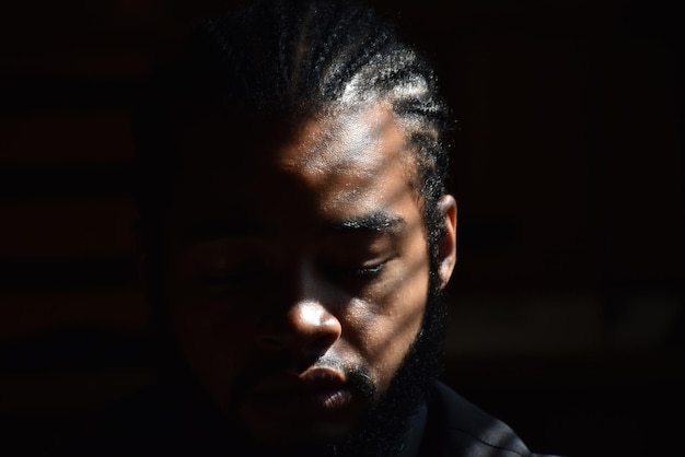 close-up portrait of young man against black background
