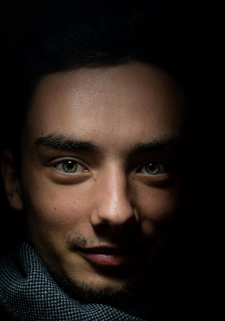 Photo close-up portrait of young man in dark room