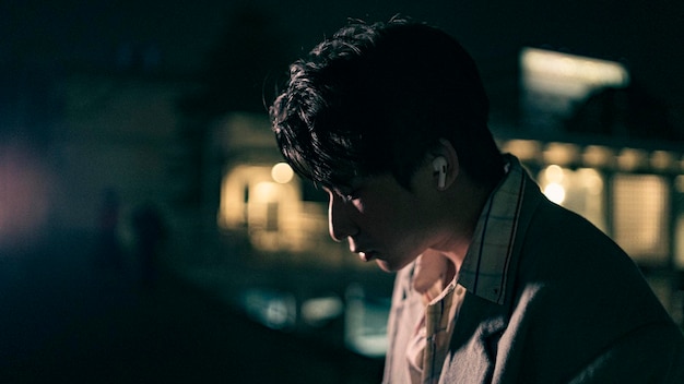 夜に目をそらしている若い男のクローズアップ肖像画