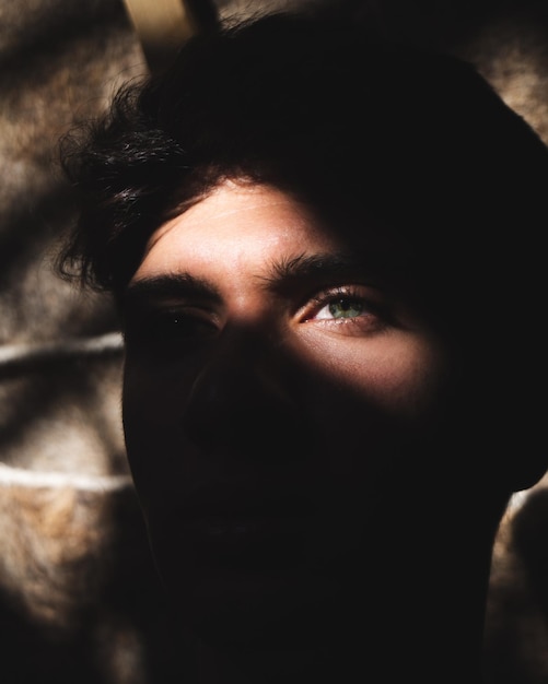 Close-up portrait of a young man in shadows