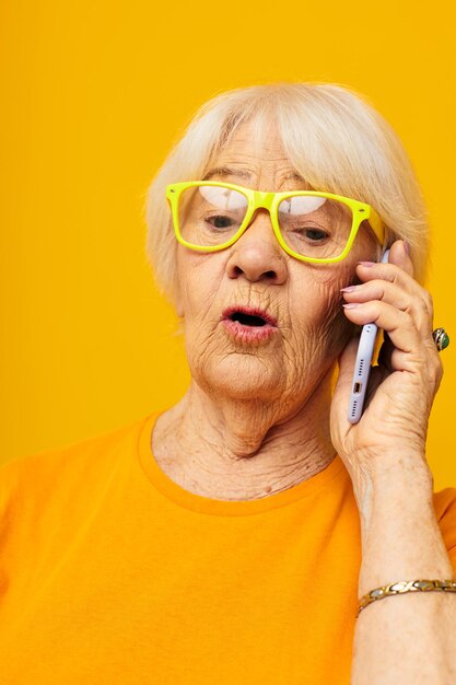 Close-up portrait of young man wearing sunglasses against yellow background