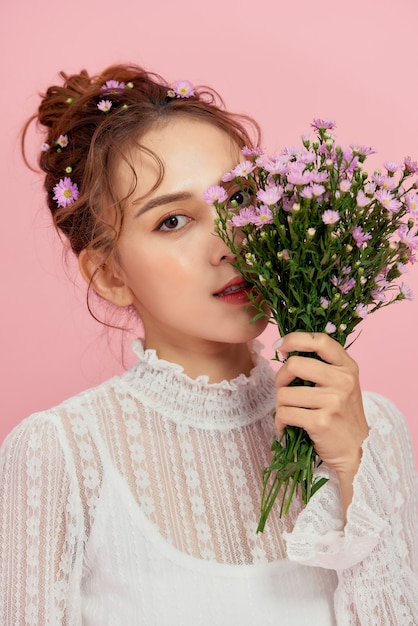 Close-up portrait of an young sexy woman with clean skin and bouquet of flowers.