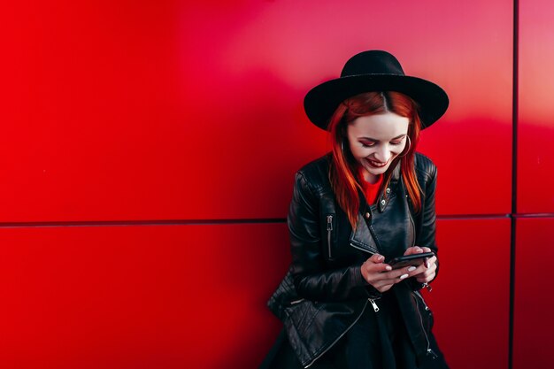 Close up portrait of a young stylish woman holding a smartphone