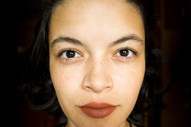 Photo close-up portrait of young woman against black background