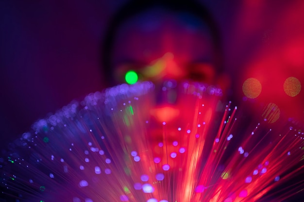 Close-up portrait of young woman against illuminated background