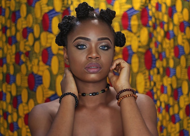 Close-up portrait of young woman against patterned wall