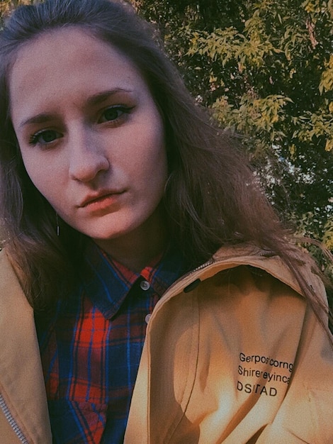 Photo close-up portrait of young woman against tree outdoors