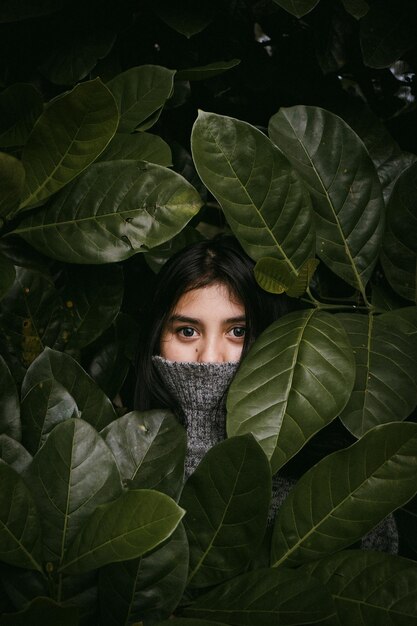 Foto ritratto in primo piano di una giovane donna tra le foglie