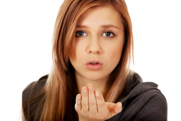 Photo close-up portrait of young woman blowing while standing against white background