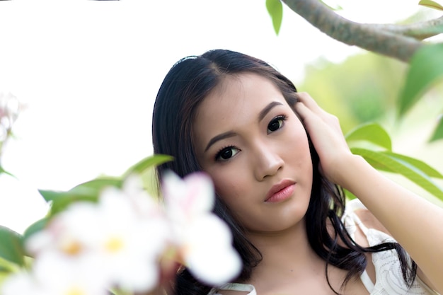 Photo close-up portrait of young woman by blooming flowers