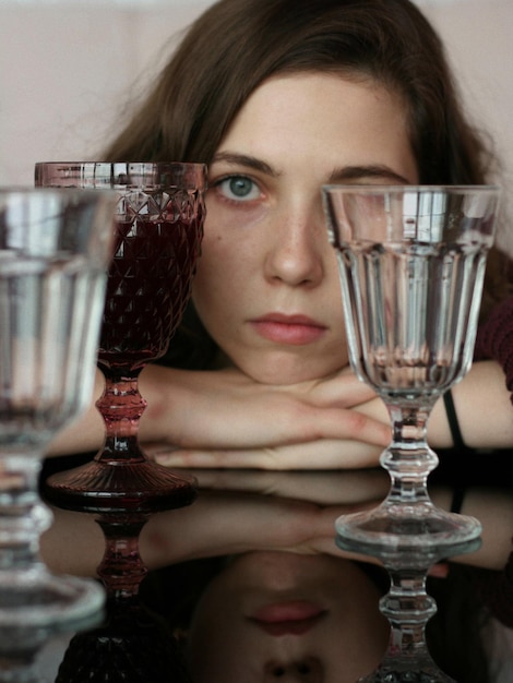 Foto ritratto in primo piano di una giovane donna con gli occhiali sul tavolo