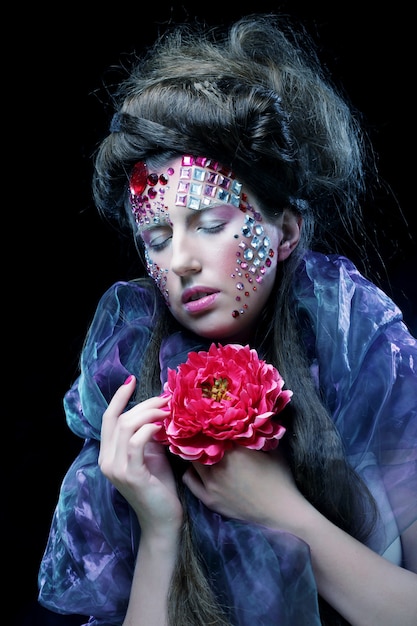 Close up Portrait of young woman in creative image  with big flowers