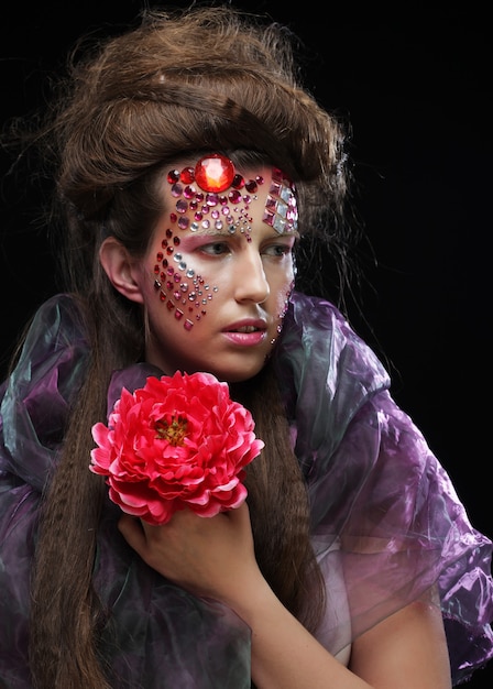 Close up Portrait of young woman in creative image  with big flowers.