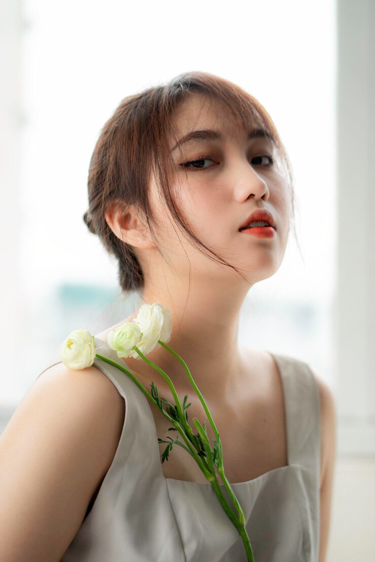 Photo 꽃 을 들고 있는 젊은 여자 의 클로즈업 초상화