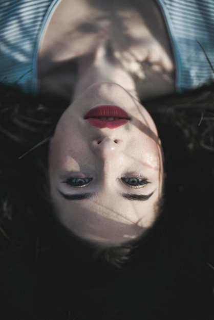close-up portrait of young woman lying on field