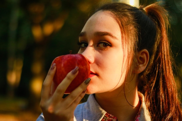 Photo close-up portrait of young woman smelling apple