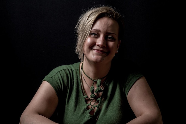 Photo close-up portrait of young woman smiling against black background