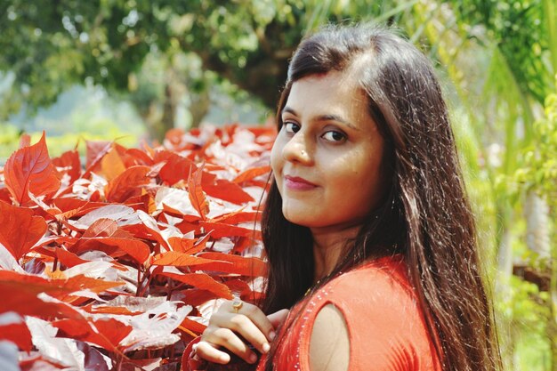 Photo close-up portrait of young woman standing by plant during sunny day